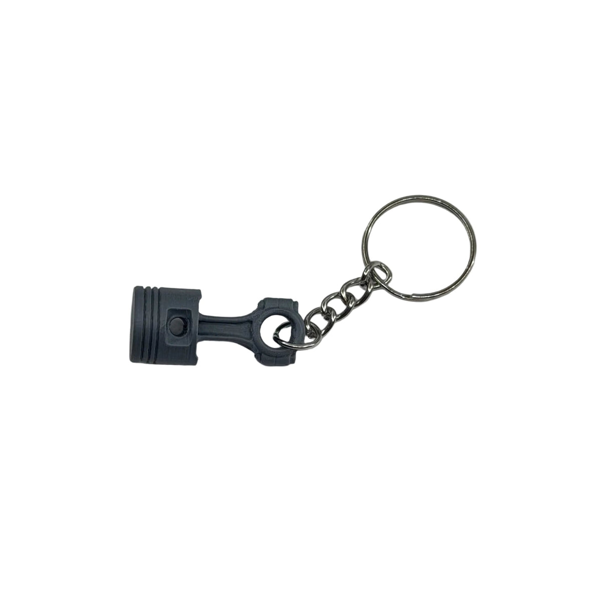 A miniature gray metal engine piston keychain with a silver split ring